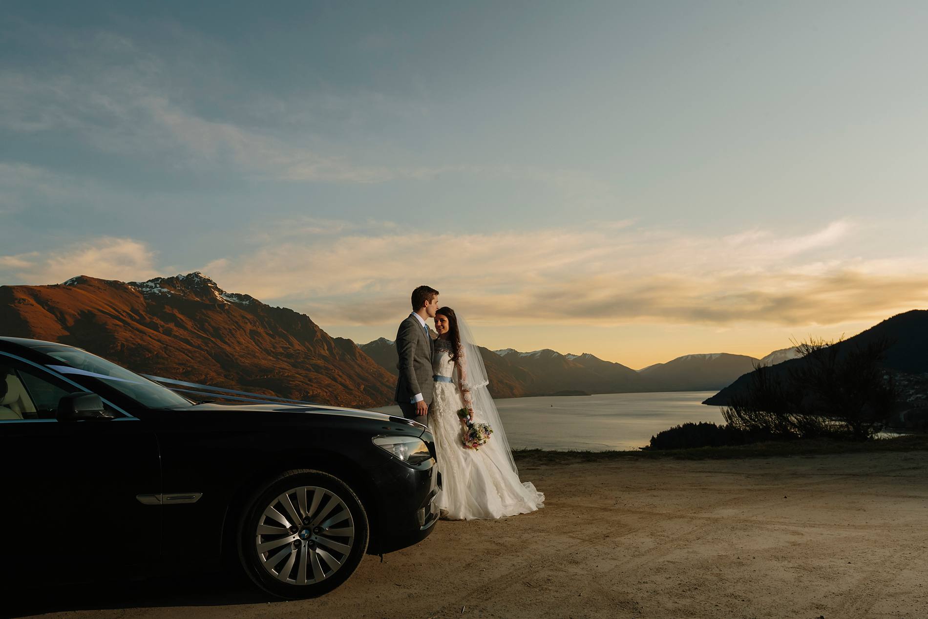 Bride and groom by car