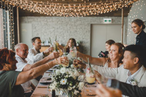 Cheers with drinks around a wedding table