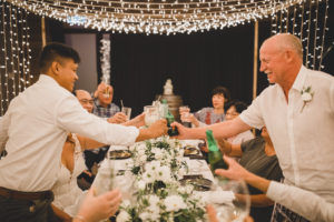 Wedding dinner cheers with groom and father in law